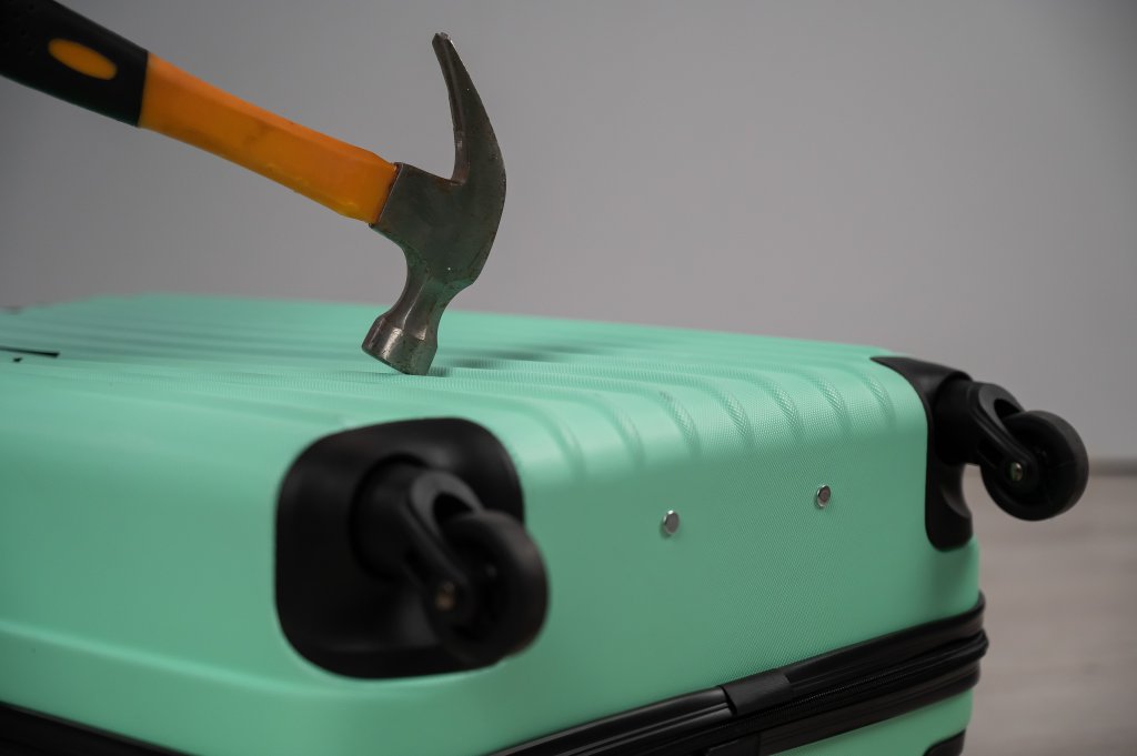 hammer hitting plastic suitcase